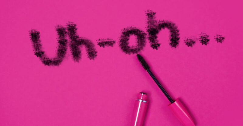 A pink tube of mascara and the writing "Uh-oh" in black smudges.