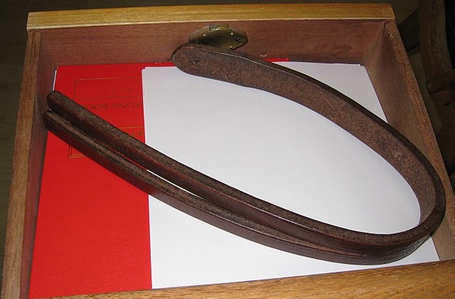 Leather tawse, or school strap, curled inside a desk.