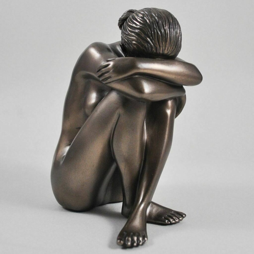 Bronze figurine of a shy nude girl drawing her knees up to her chest