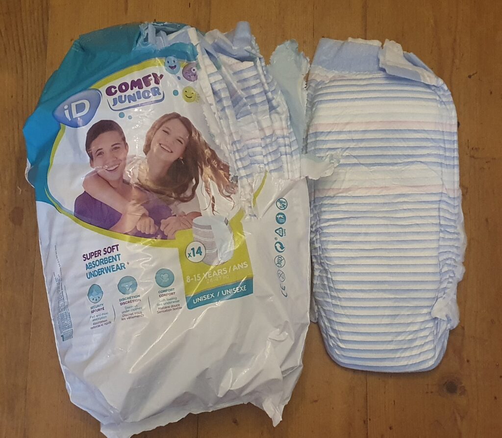 An open pack of teenage pullup nappies, with colourful stripes. The package has smiling teens on it.