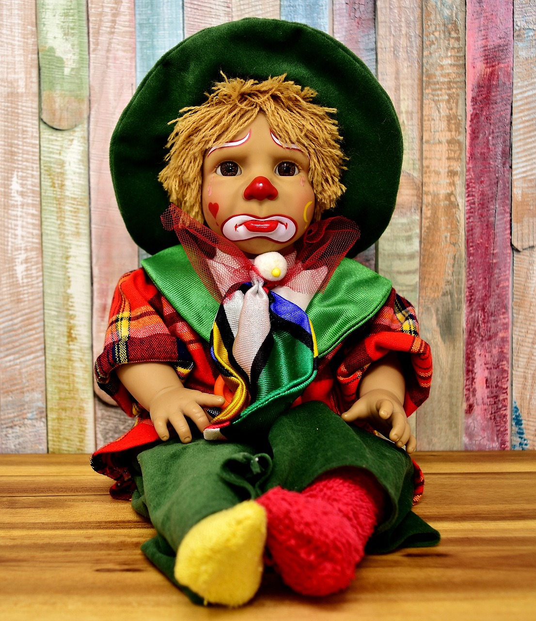A sad clown doll with patchwork suit and woollen hair.