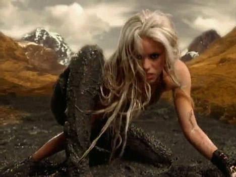 Pop singer Shakira crouched in a pool of mud, looking seductively out at us.